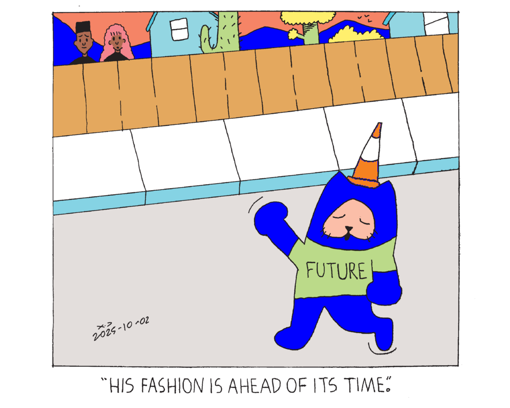 Power cat walking down the street with a traffic cone on his head and a green shirt that says future. A man and a woman are standing behind a fence looking at him and the woman says his fashion is ahead of its time. 